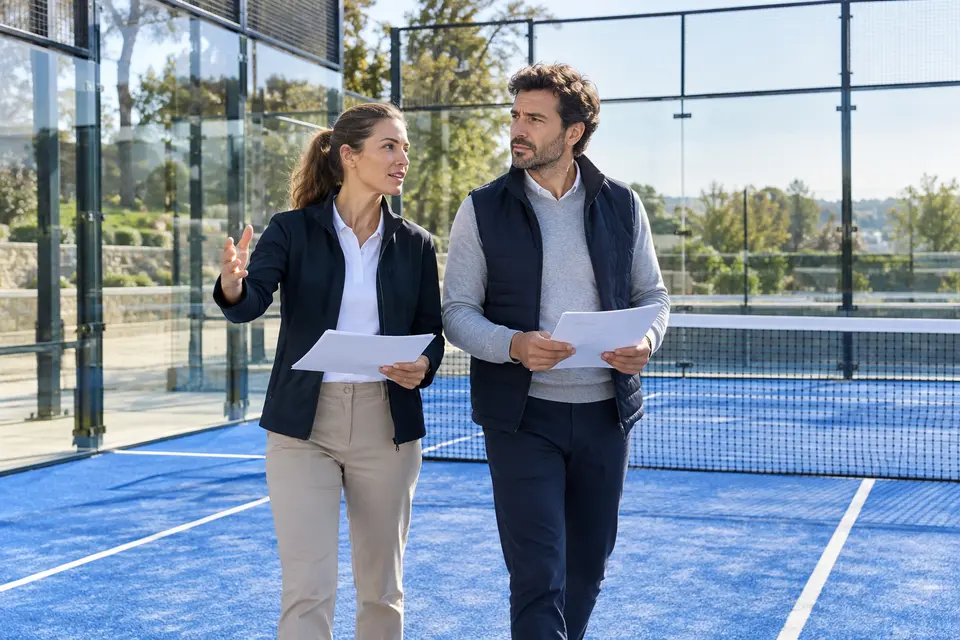 Scène illustrative de spécialistes inspectant une installation de padel